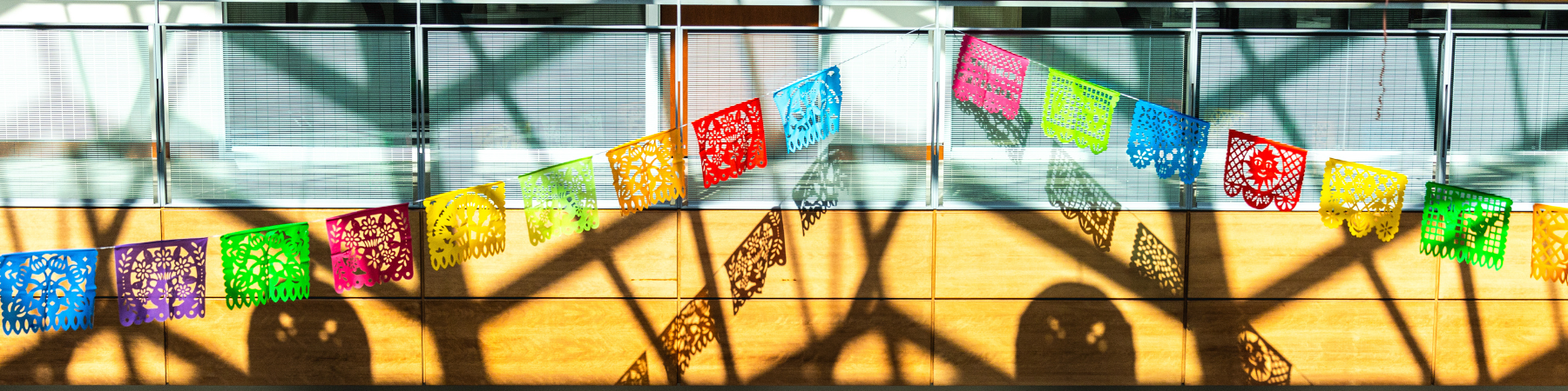 A papel picado banner across the Cuneo Center Atrium for Día de Los Muertos.